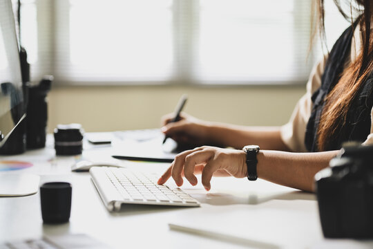 Close up of female photographer working on photo editing in a bright creative studio - Powered by Adobe