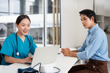 Attractive young female doctor consulting with a patient inside her office at a hospital. young man...