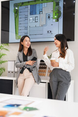 two designer in office, enjoying a coffee break and engaging in friendly conversation, fostering...