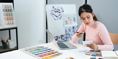 Female interior designer selects new painting colors and finishing material , develops future...