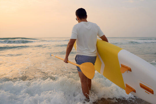 Man enjoying paddleboarding on a serene beach