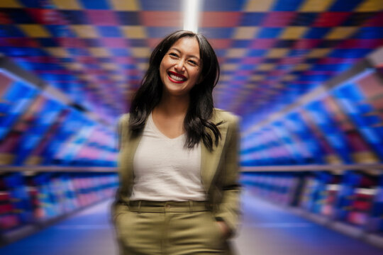 Confident businesswoman smiling in a colorful urban tunnel - Powered by Adobe