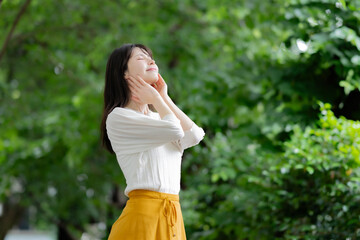 新緑の中で立つ女性