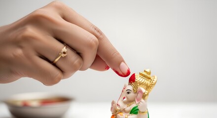 Obraz premium Woman placing red flower on idol of Lord Ganesha for Ganesh Chaturthi 