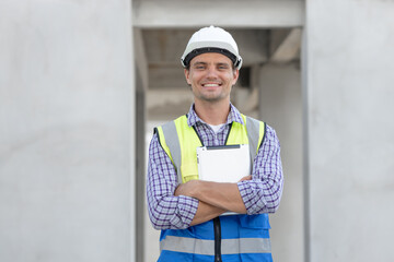Portrait of handsome successful architect standing with arms crossed in building in construction process.