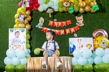 Indian Baby Boy happy moments at Birthday Celebration with forest theme decor background