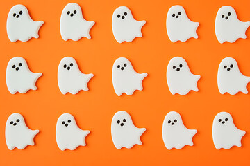 White cutouts of bats and ghosts on an orange background