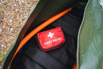 A first aid kit is sitting inside of a green bag