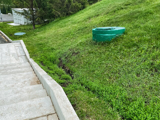 A picturesque lush green hill featuring a step pathway that guides visitors through the landscape,...