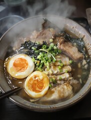 Steaming Bowl of Ramen with Egg Pork and Green Onions Close Up