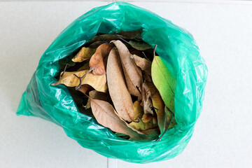 Top View Of Green Trash Bag Containing Organic Waste Or Dried Leaves