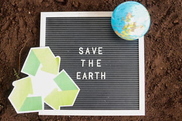 Save The Earth Letter Board With Globe And Recycle Symbol On Rich Brown Soil
