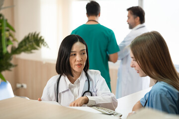 Asia doctor woman working and talking with Caucasian woman medical student at hospital	