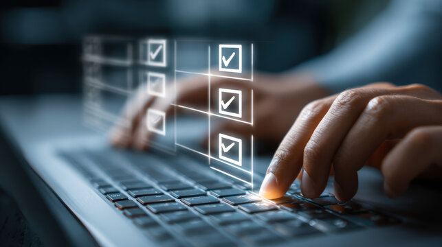 A person is completing a digital checklist on a laptop, hove their fingers over the keyboard to select options in the virtual form on the screen displayed.