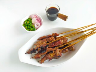 Satay or Sate Kambing, meat satay served with slice red onion, ​​chili, ​​tomatoes with soy...