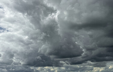 Obraz premium Stormy sky with dark, snowy clouds on a spring day. Clouds are floating across the sky. Dark blue clouds swiftly floating across blue sky. Storm dramatic clouds are floating across the sky. Hurricane.