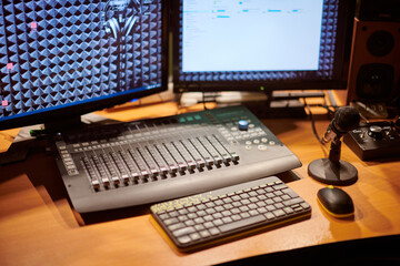 Professional audio mixing console, two monitors and microphone, essential tools for sound recording...