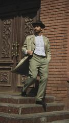 Man in vintage outfit walks down stairs in urban setting. Concept of cinematic retro portraits,...