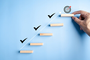 Business growth success and achievement with hand arranging wooden steps and check marks, goal...