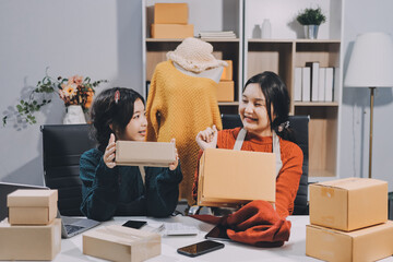 Portrait of Starting small businesses SME owners, two Asian woman check online orders Selling...