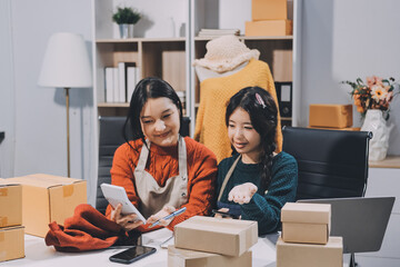 Portrait of Starting small businesses SME owners, two Asian woman check online orders Selling...