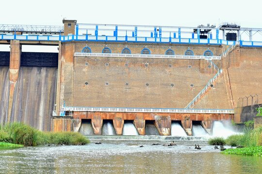 Front view of the historic Vaigai Dam near Theni, Tamil Nadu, India, showing water being released through sluice gates. This important structure supports irrigation and water supply across the region