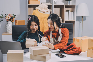 Portrait of Starting small businesses SME owners, two Asian woman check online orders Selling...