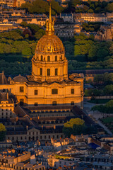 Close-up aerial view of the Golden Dome of the Invalides Palace beautifully illuminated during the golden hour at sunset in Paris.
