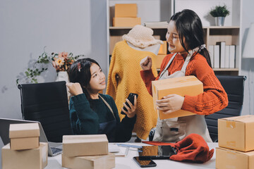Portrait of Starting small businesses SME owners, two Asian woman check online orders Selling...
