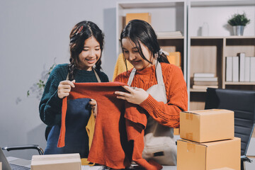 Portrait of Starting small businesses SME owners, two Asian woman check online orders Selling...