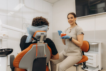 Dentist showing teeth model to patient in dental clinic