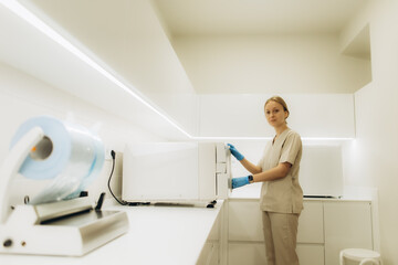 Nurse using sterilization equipment in modern clinic laboratory