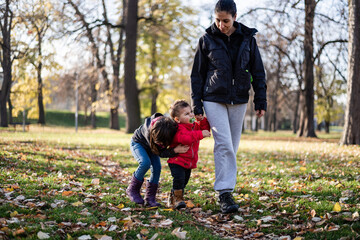 Mother walking with children in autumn park