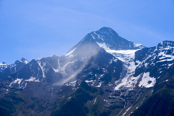 Doing hiking with mountain panorama in the Swiss Alps at Lötschental Valley on a sunny late spring...