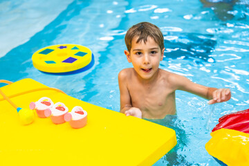 Child playing with floating toys in swimming pool