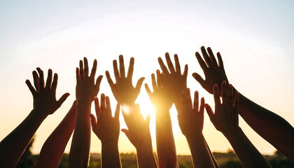 Silhouettes of many hands raised towards the setting sun
