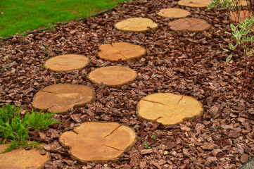 rustic garden pathway with wood slices creates inviting natural walkway. charming wooden stepping...