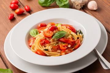Spaghetti con pomodori pachino, cipolla, basilico e olio extravergine di oliva, pasta italiana,...
