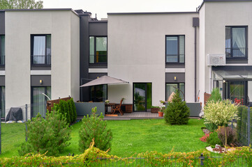 modern townhouse exterior with lush garden showcasing contemporary design and outdoor umbrella on...
