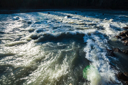 The Elwha River, fast flowing water flowing around a rock in the stream.
