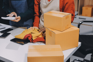Portrait of Starting small businesses SME owners, two Asian woman check online orders Selling...