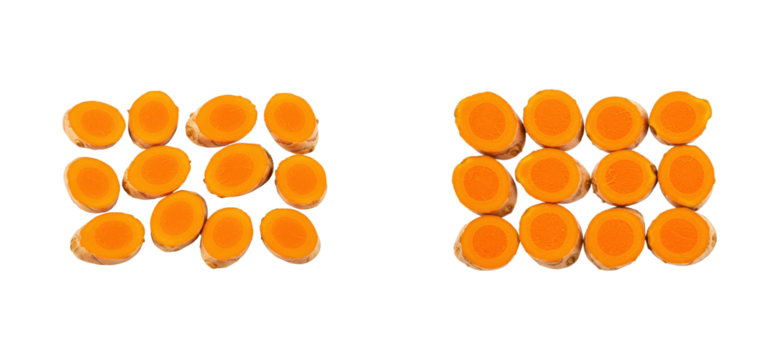 Bright orange turmeric halves arranged in symmetrical pattern on black background