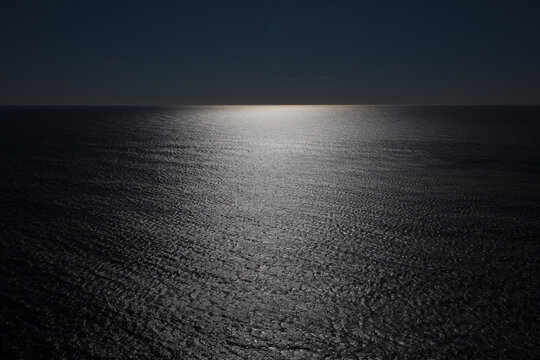 The vast ocean and reflections of light on the water surface, black and white image.  