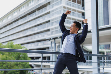 Excited businessman celebrating success in urban setting