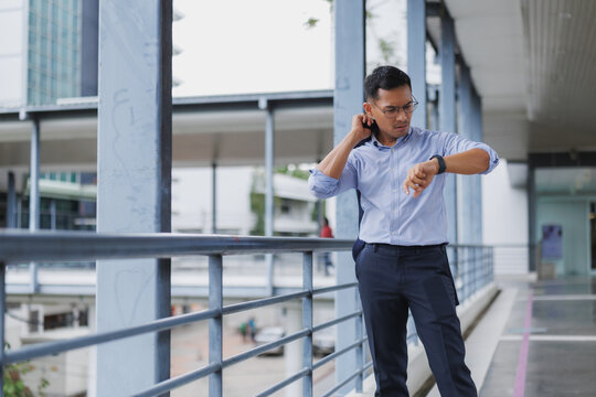 Businessman checking time on smartwatch in modern city setting