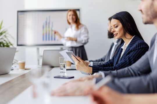 Selective focus on businesswoman with tablet following seminar at boardroom.