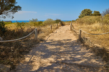 Tourist walking path on Cape Sant Antoni near Xabia, Spain, bordered by rope and wooden posts,...