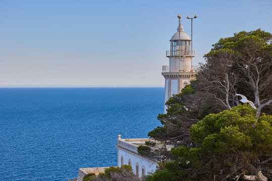 Scenic view of the lighthouse at Cabo de la Nao, located on a high cliff above the Mediterranean Sea in the province of Alicante, Spain, under a clear blue sky