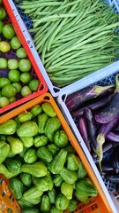 Various kinds of fresh vegetables in plastic boxes sell at traditional market.