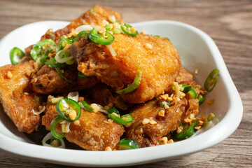 A closeup view of a pile of salt and pepper chicken wings.